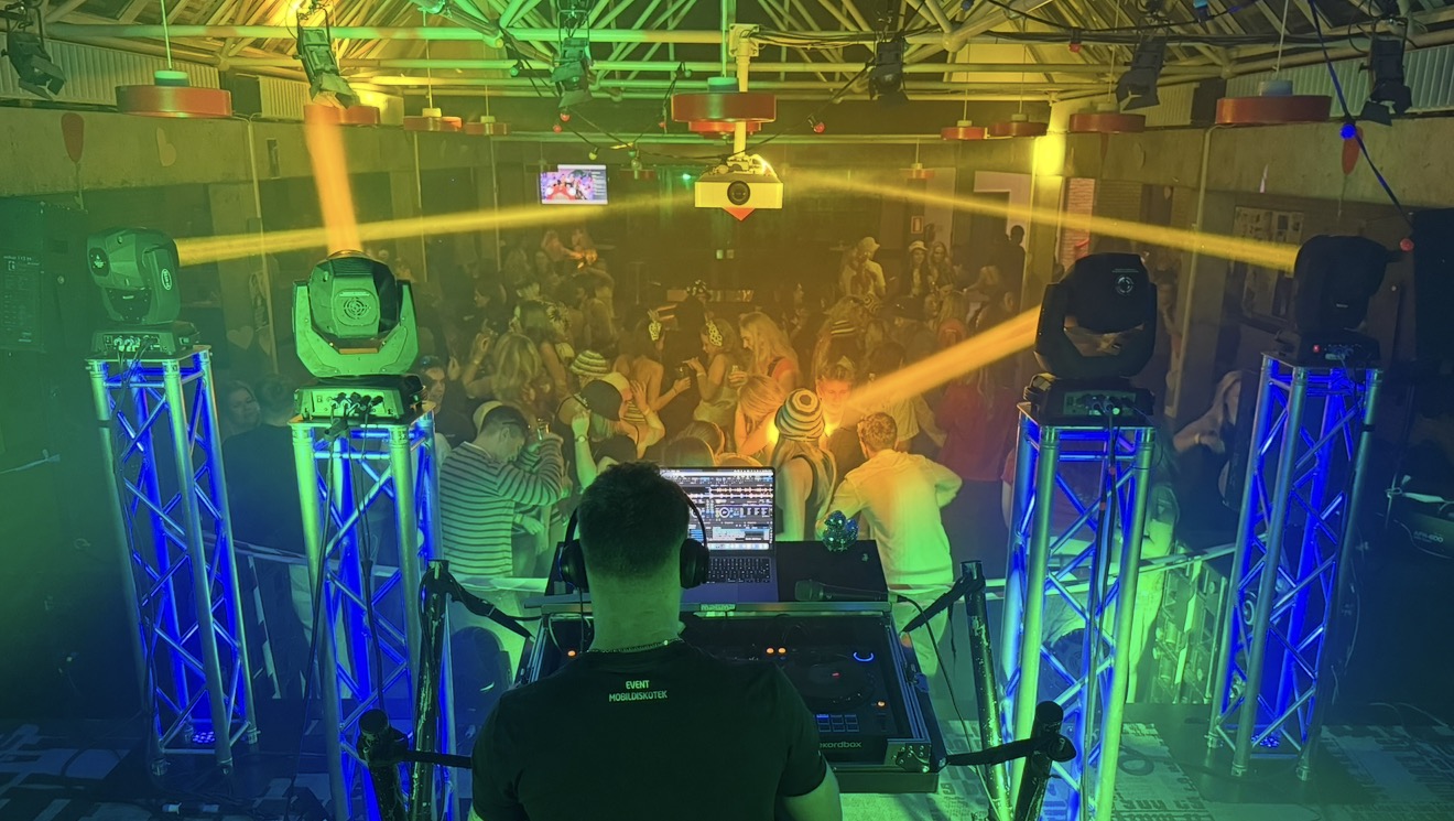 Fusion Nord DJ med udsigt over et fyldt dansegulv og gule lysstråler